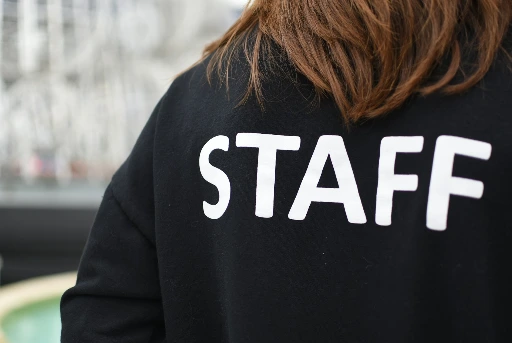 a person wearing a black shirt that says staff